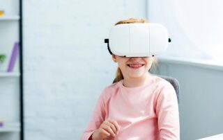 Smiling redhead child using virtual reality headset at home