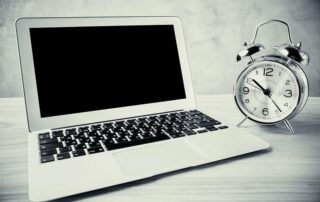 Blank laptop screen and alarm clock in black-and-white. Mock up