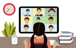 Female student sitting in front of computer at her desk. Looking at a her classmates who are also participating in virtual learning.