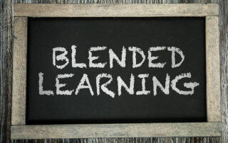 The words, Blended Learning, is written in white chalk on a black chalkboard