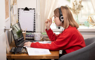 Female student learning, studying from home with a laptop computer, headphones during Covid-19. Home school kid concept. Quarantined and Social distancing concept.