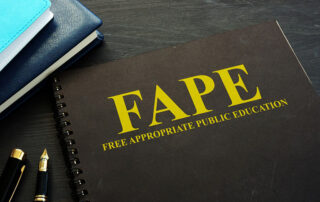 The words, FAPE Free Appropriate Public Education, written on a book cover sitting on top of a desk